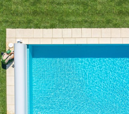 Outdoor Residential Swimming Pool Maintenance Skimmer Filter Cleaning Performed by Professional Caucasian Pool Technician. Industrial Theme.